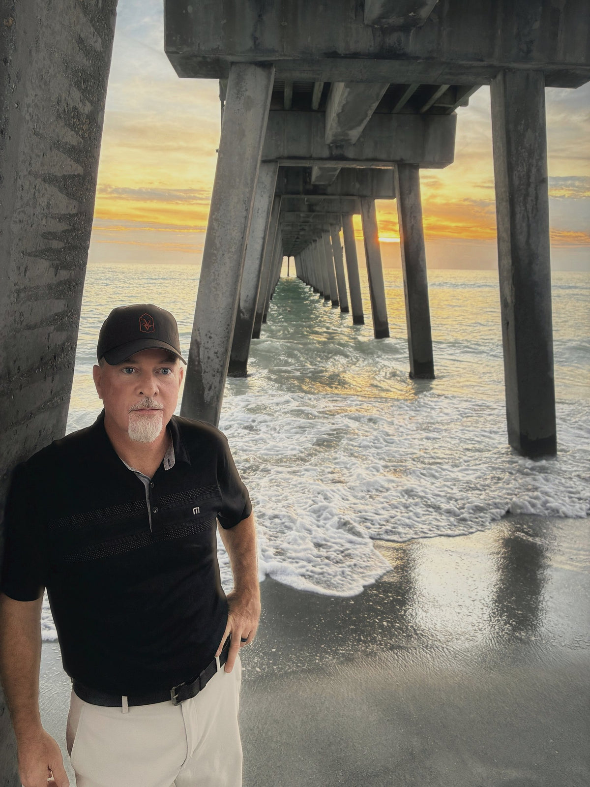 Venice Vida co-founder in the black VV hat under the Venice Fishing Pier at sunset