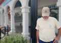 Venice Vida co-founder wearing the Mediterranean Heritage Tee in Ivory and Whitewash Hat beneath the Mediterranean arches of downtown Venice, Florida