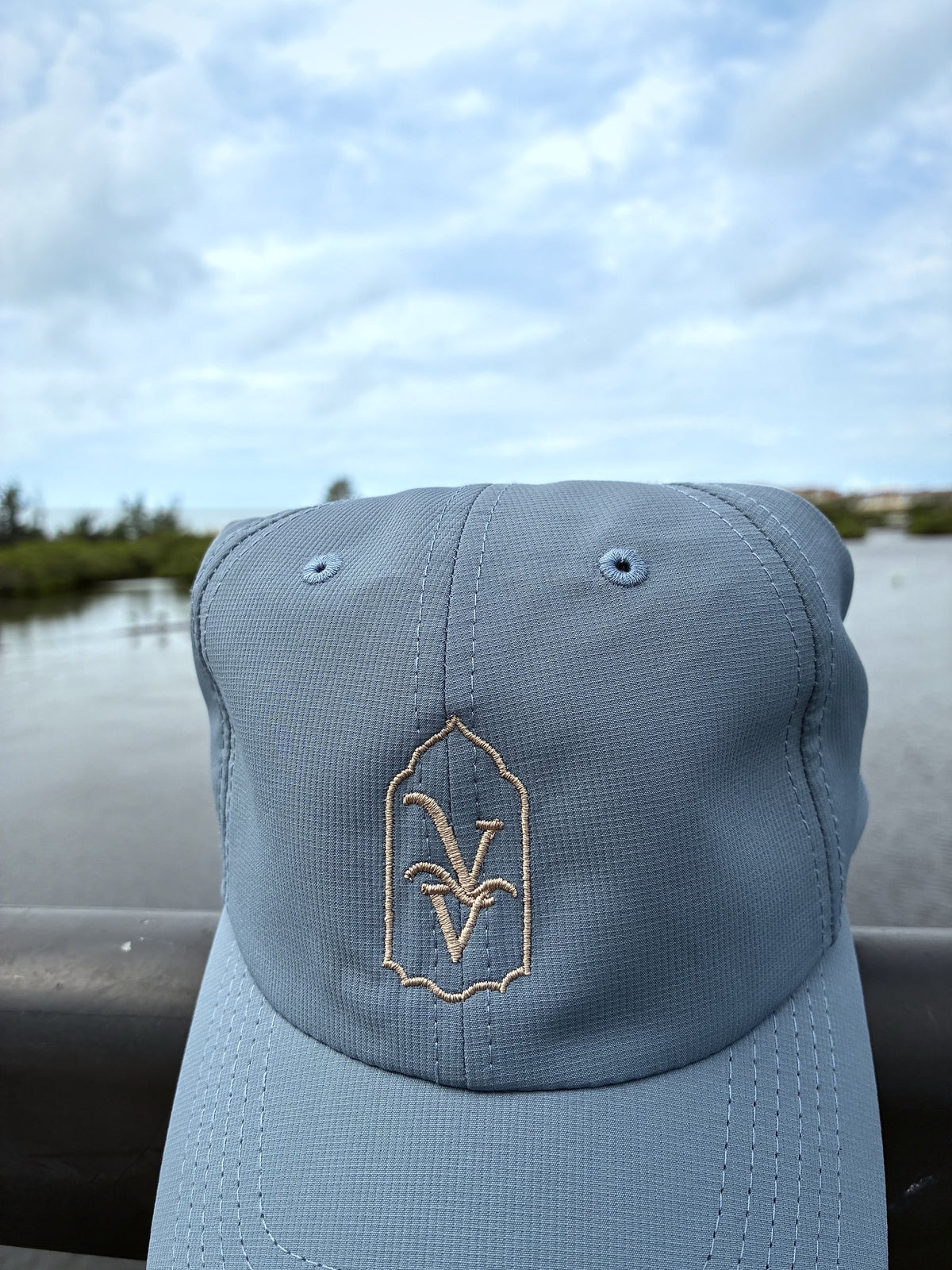 Venice Vida Signature Hat in Breaker Blue with embroidered VV mark, by the water in Venice, Florida