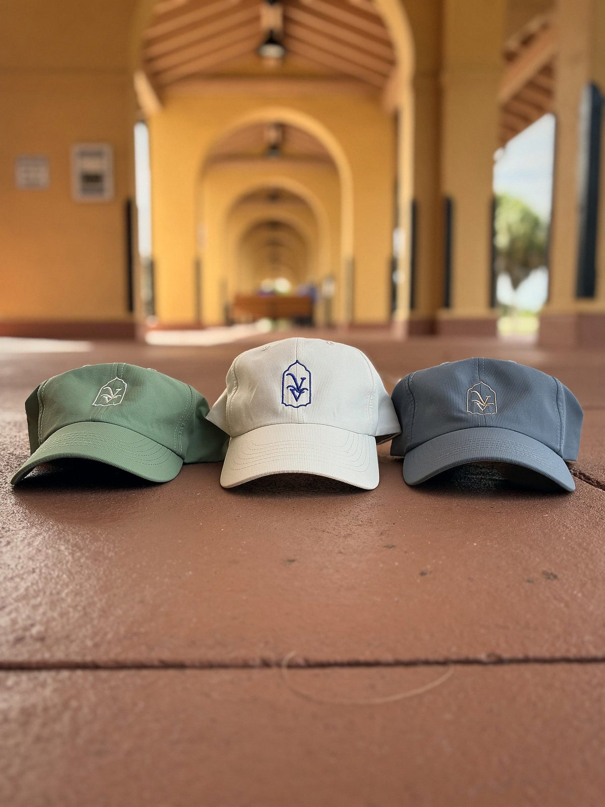 Venice Vida Banyan, Whitewash and Signature hats side by side under Mediterranean-style arches in Venice, Florida